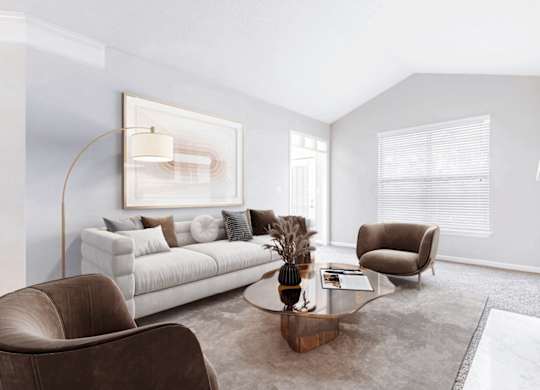 A living room with a white couch, a brown armchair, and a coffee table.