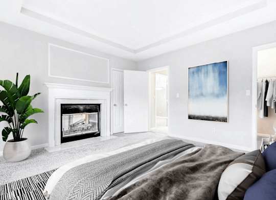 A bedroom with a large bed and a fireplace.