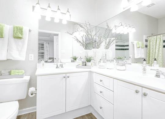 A white bathroom with a toilet, sink, and mirror.
