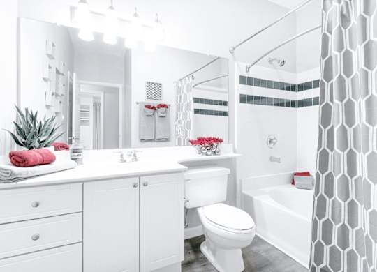 A white bathroom with a toilet, sink, and bathtub.