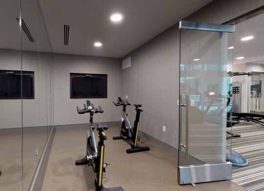 Spin/flex studio facing two exercise bicycles and a large mirror.