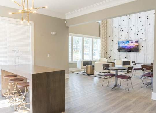 A modern kitchen with a bar area and a dining table set up at Foxwood Apartments, North Carolina
