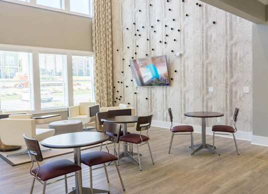 A room with a table and chairs and a painting on the wall at Foxwood Apartments, Raleigh-Durham