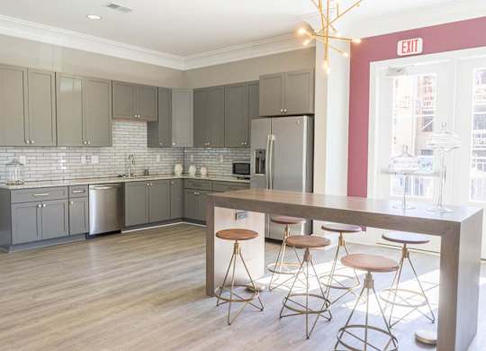 A kitchen with a bar area and stools at Foxwood Apartments, Raleigh-Durham