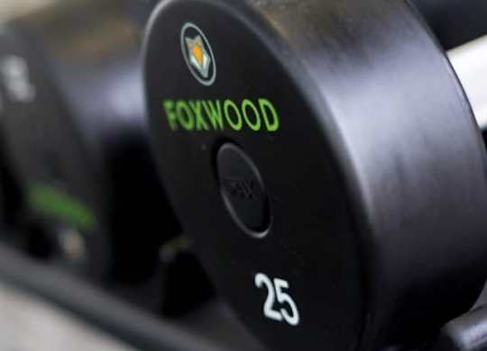 A close up of a black dumbbell with the word FOXWOOD and the number 25 printed on it at Foxwood Apartments, Raleigh-Durham, North Carolina
