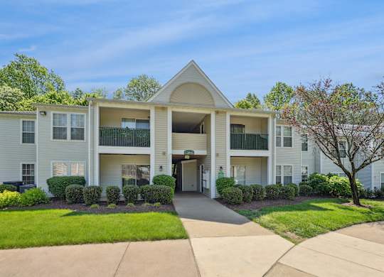 A large apartment complex with a green lawn in front.