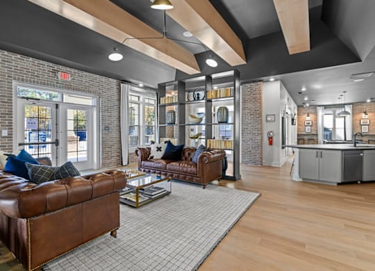 A living room with a brown leather couch and a grey rug at Litchford 315 Apartments, Raleigh