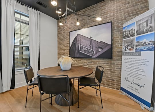A room with a brick wall and a poster that says New Leasing at Litchford 315 Apartments, North Carolina