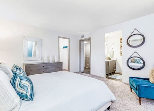 A bedroom with a large bed and a blue couch at Madison Southpark Apartment Homes, Charlotte