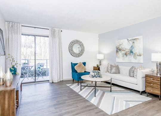 A living room with a blue chair and a white couch at Madison Southpark Apartment Homes, Charlotte