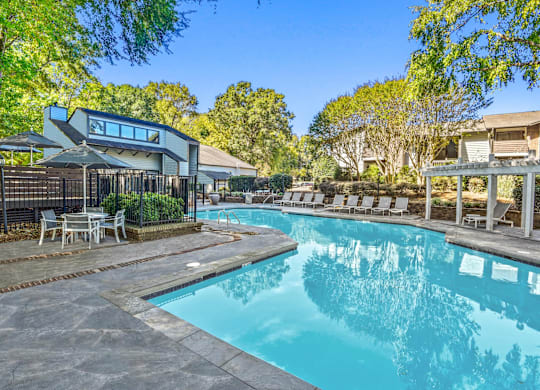 A swimming pool surrounded by a deck and lounge chairs at Madison Southpark Apartment Homes, Charlotte, NC, 28226