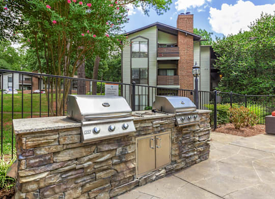 A stone wall with a grill on top of it at Madison Southpark Apartment Homes, Charlotte