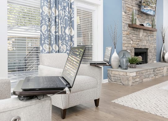 A laptop is open on a couch in a living room at Madison Southpark Apartment Homes, Charlotte, North Carolina
