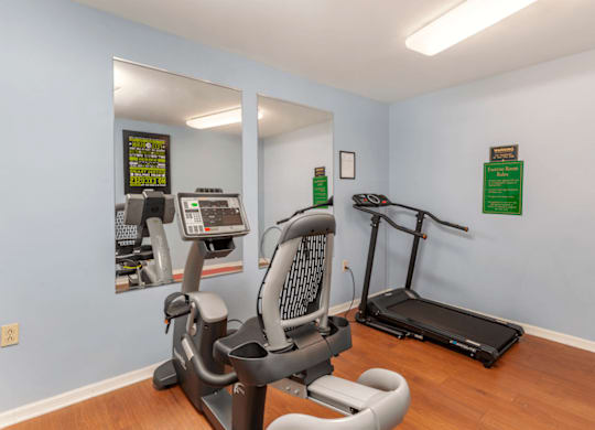 Fitness Center with Exercise Equipment and Mirror Accents on Wall