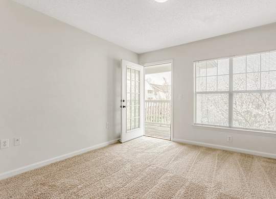 A room with a carpeted floor and a window with blinds. at The Grayson Apartment Homes, Charlotte, 28262