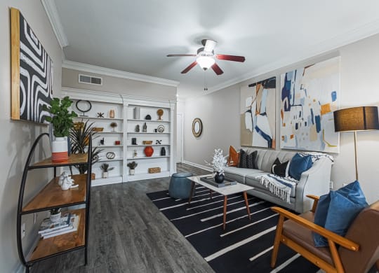 staged living room with hardwood-style flooring and ceiling fan
