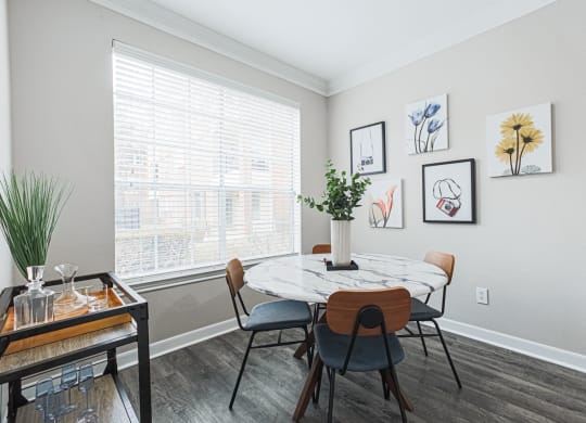 a dining room with a table and hardwood-style flooring