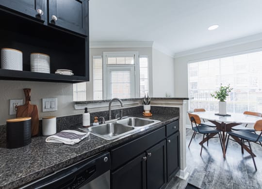 kitchen with black cabinetry and granite-style countertops