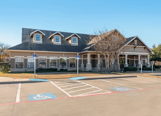 Clubhouse exterior with parking lot and native landscape