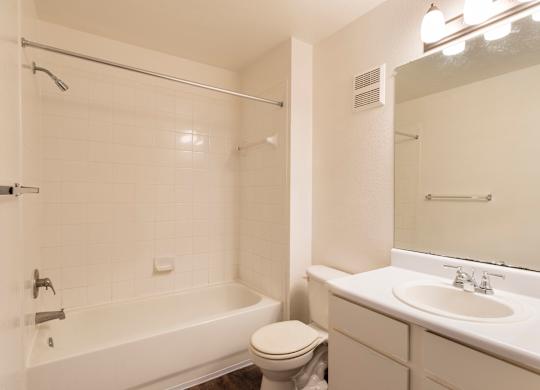A white bathroom with a toilet, sink, and bathtub.