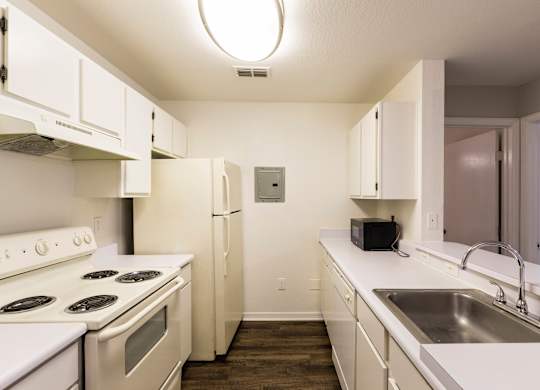 A kitchen with white appliances and cabinets.