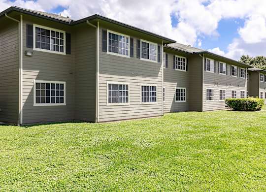 A row of apartments with grass in front.