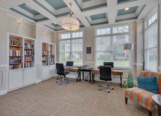 A room with a desk, chairs, and bookshelves.