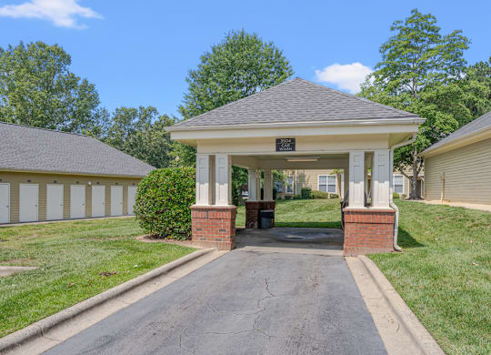 A small building with a brick pillar in front of it.