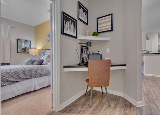 A room with a bed, desk, and chair.