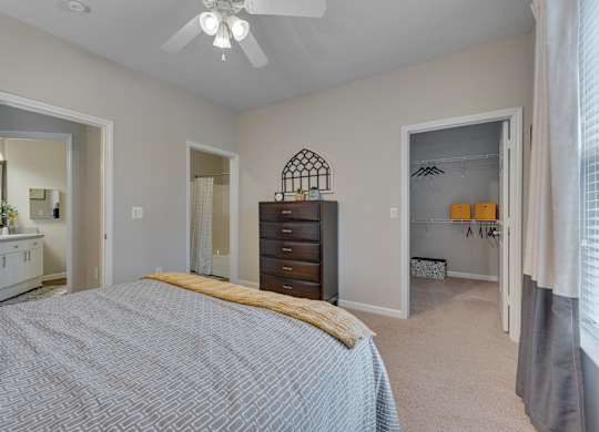 A bedroom with a bed, dresser, and mirror.