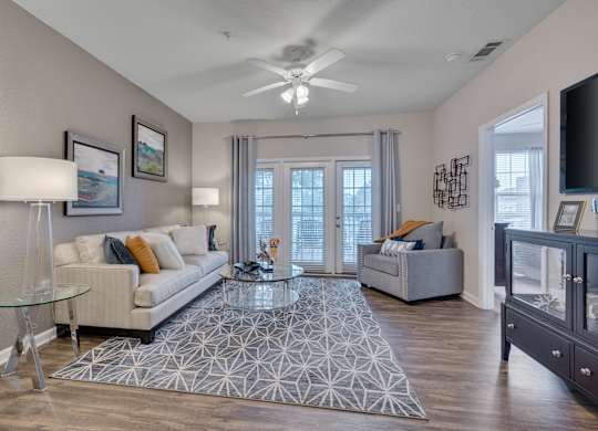 A living room with a glass table and a white couch.