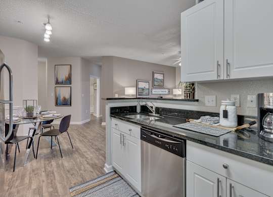 A kitchen with a dining table and chairs.