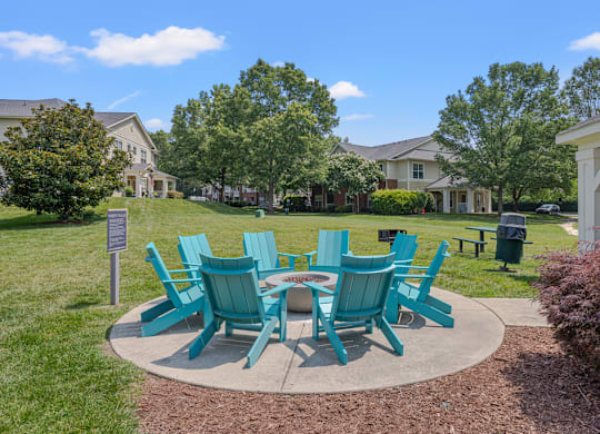 A set of green chairs and a table are arranged in a circle on a concrete slab.