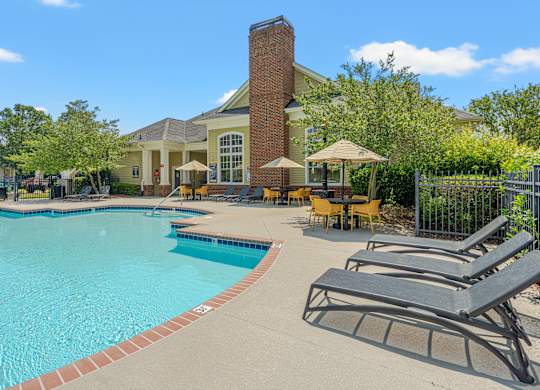A pool with a red brick chimney behind it.