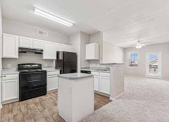 A kitchen with white cabinets and black appliances.