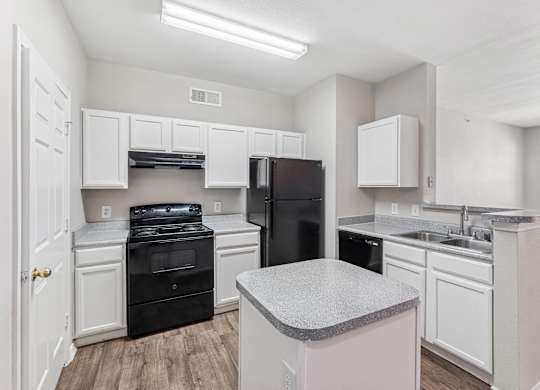 A kitchen with black appliances and white cabinets.