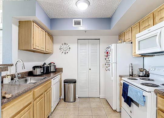 A kitchen with white appliances and wooden cabinets.