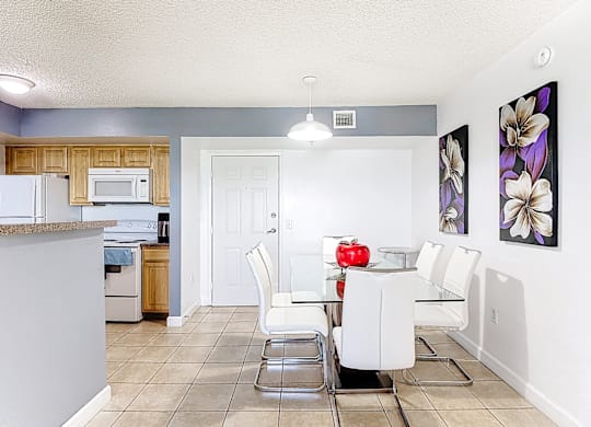A kitchen with a dining table and chairs.