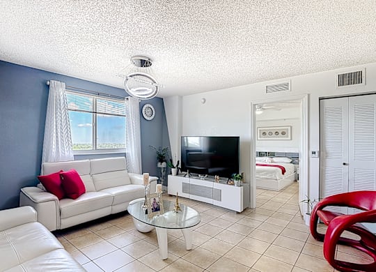 A living room with a white couch and a television.