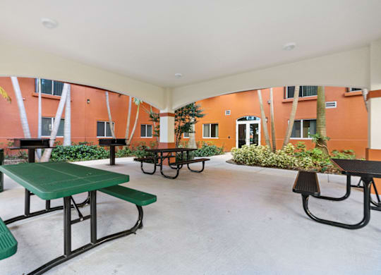 A patio with tables and chairs and plants.