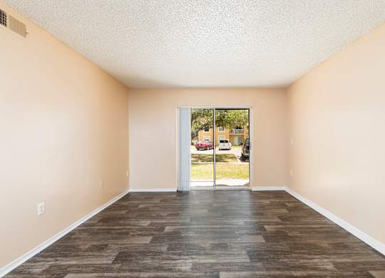 A room with a wooden floor and a sliding glass door.