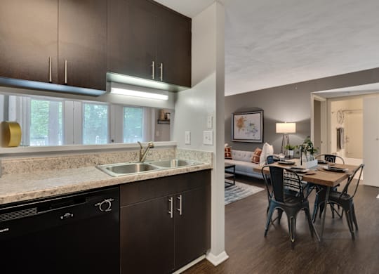 A modern kitchen with dark brown cabinets and a black dishwasher.
