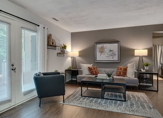 A living room with a grey sofa, a blue armchair, and a coffee table.
