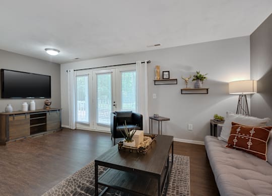A living room with a couch, a coffee table, and a television.