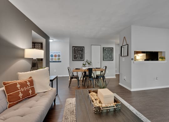 A living room with a grey couch and a wooden coffee table.