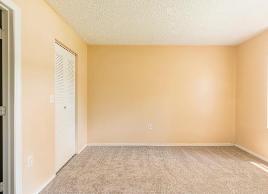 A room with beige walls and carpeted floor.