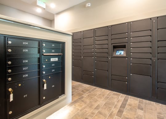 Mail room  with black painted mail storage lockers and brown tile floor