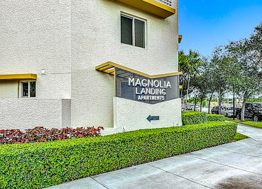 A building with a sign that says Magnolia Landing Apartments.