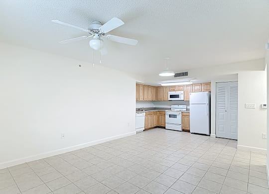 A kitchen with white appliances and wooden cabinets.