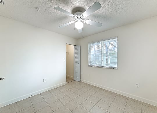 A room with a ceiling fan and a door.